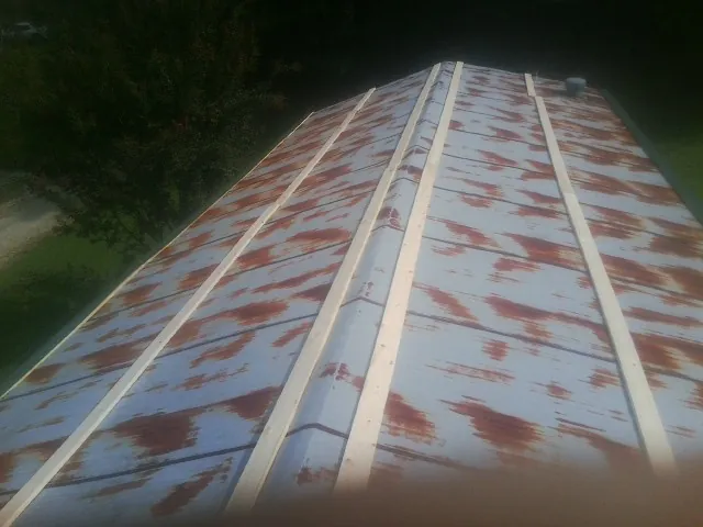 Rusted metal roof panels with new wood purlins before replacement — Storm Damage Roof Repair in Mcclusky by Roofing Brothers