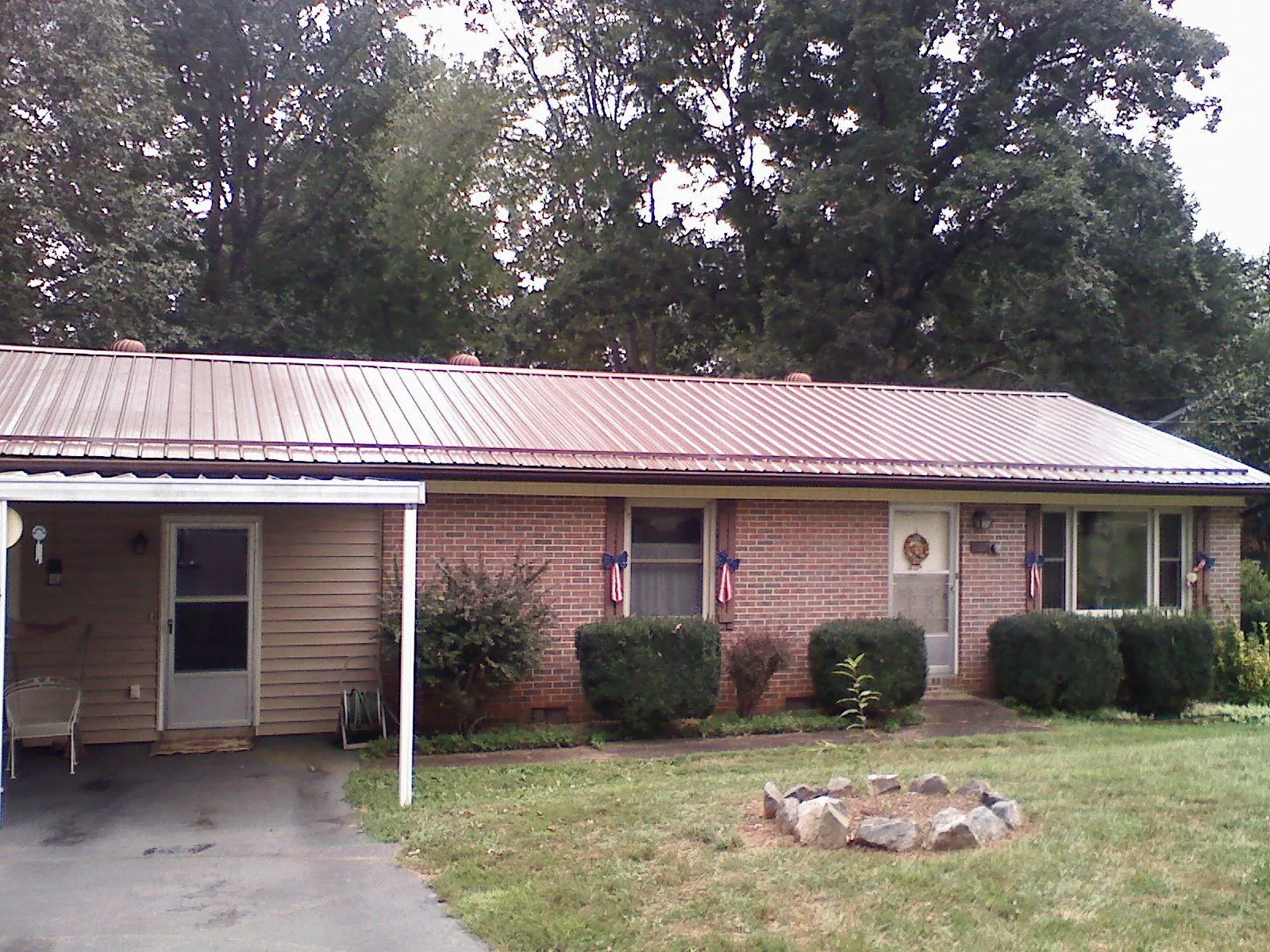 Bronze metal roof and carport on a brick ranch home — Roof Repair work by our crew in Mcclusky